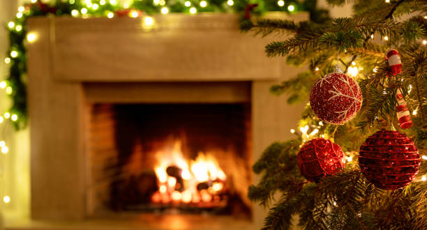 istock Christmas tree close up on blurred burning fireplace background 1290648272