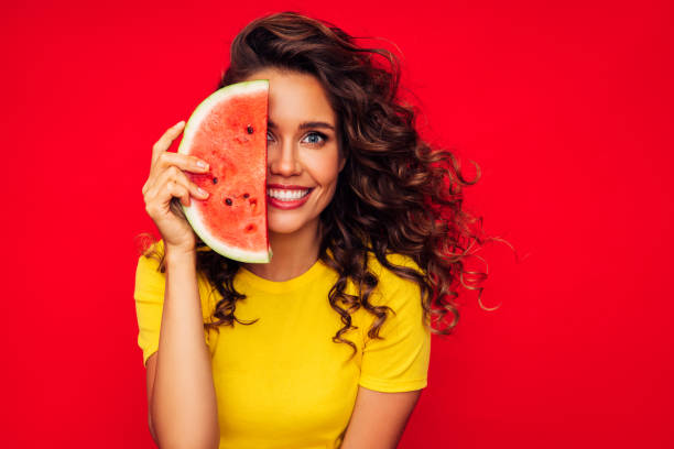 istock Smiling young woman holding watermelon 1290648820