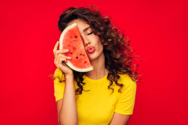 istock Smiling young woman holding watermelon 1290648836