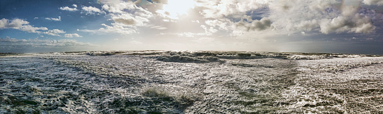 Stomy panorama over stormy sea with big foamy waves and dramatic sky.