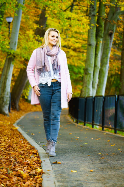 istock Woman walking in autumn park 1290649777