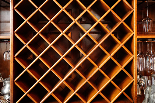 empty wooden wine cabinet. possession of alcohol in a bottle at a bar or at home.