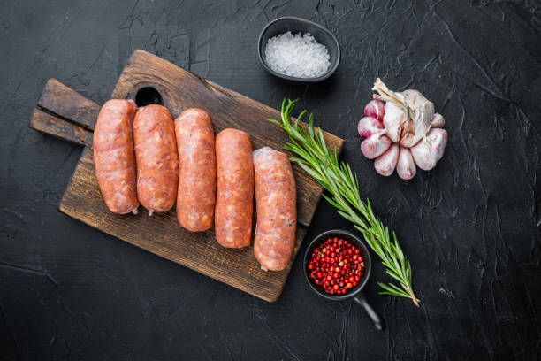 istock Raw pork sausages, top view, on black background 1290653008