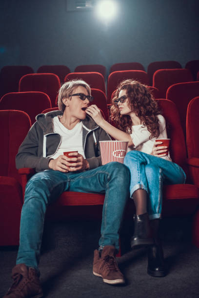 istock Young people are feeding each other popcorn in cinema. 1290653843