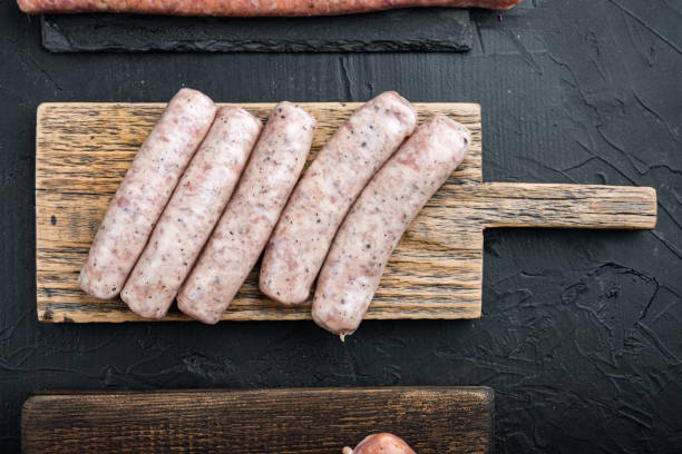 istock Raw chicken sausages, flat lay, on black background 1290654367