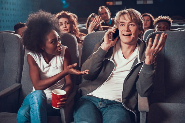 istock Young guy communicates on phone in movie theater. 1290654504