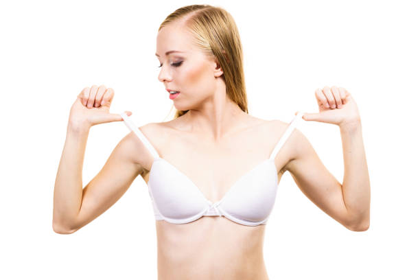 istock Young woman holding bra strap 1290654574