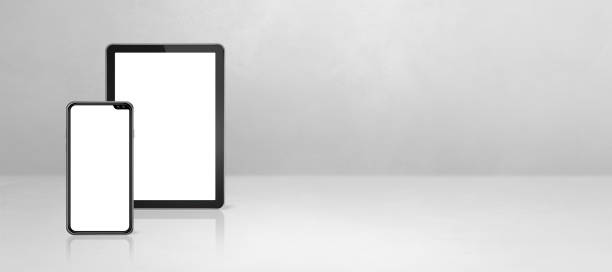 istock Mobile phone and digital tablet pc on white concrete office desk. Background banner 1290655262