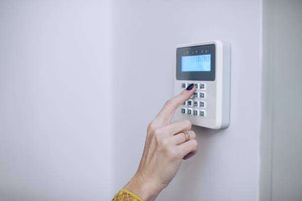 istock Security home system. Woman entering secret code on home alarm 1290655587