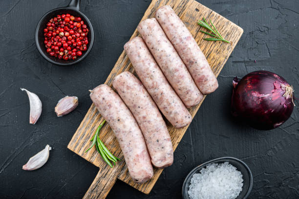 istock Raw chicken sausages, flat lay, on black background 1290656339