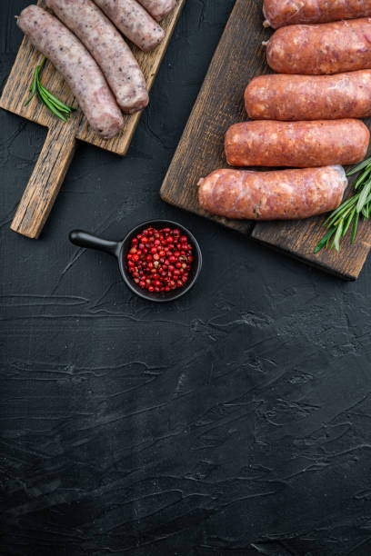 istock Assorted raw homemade sausages, flat lay with space for text, on black background 1290656841