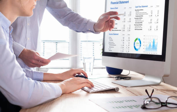 istock Accountants working on financial statement on computer screen in office. Team of consulant auditing finance and business operations reports with income data. Corporate management and governance 1290657898