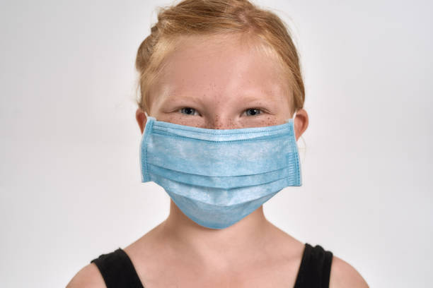 portrait of pretty little red haired sportive girl in sportswear wearing medical mask, smiling at camera while standing isolated over white background - gymnastics smiling little girls only isolated on white imagens e fotografias de stock