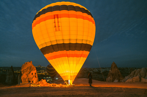 Young Caucasian woman looking at setting  of hot air balloon in Cappadocia