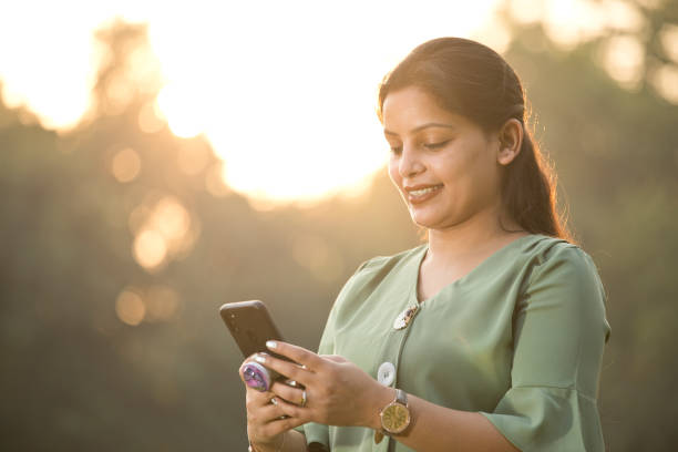istock Woman texting on mobile phone at park 1290659029