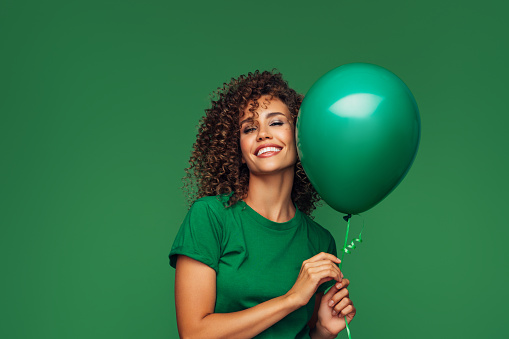 Beautiful woman holding a green balloon
