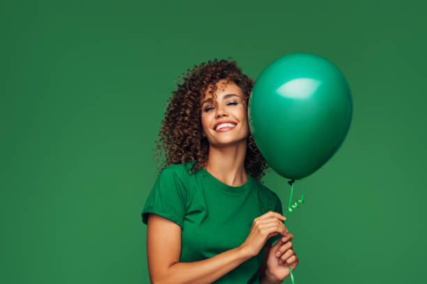 beautiful woman holding a green balloon - outdoor lifestyle imagens e fotografias de stock