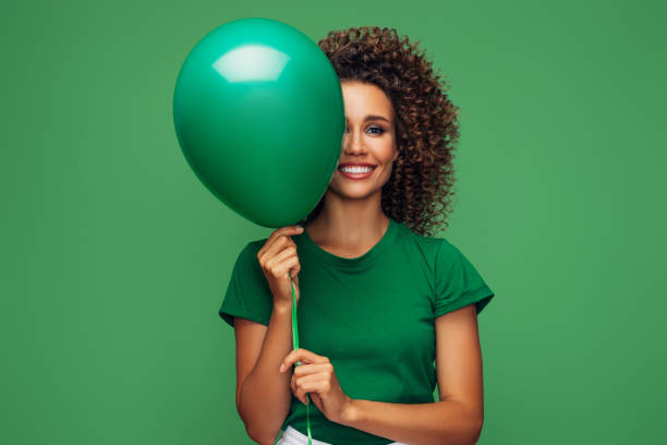 istock Beautiful woman holding a green balloon 1290660366