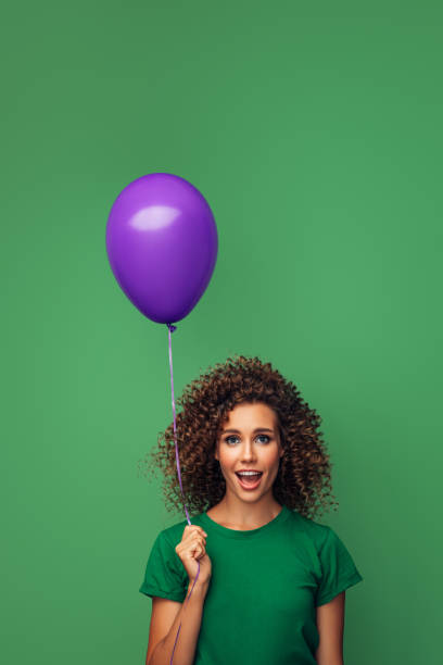 istock Beautiful woman holding a violet balloon 1290660401