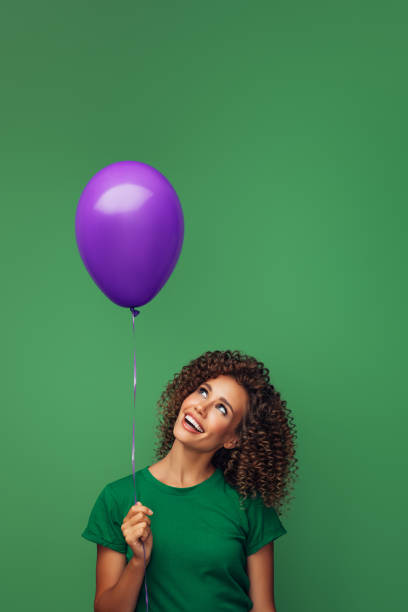 istock Beautiful woman holding a violet balloon 1290660427