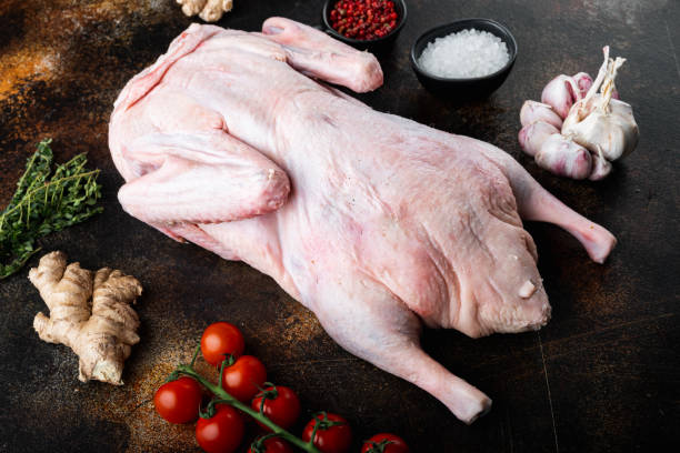 istock Raw young goose on old dark background 1290665309
