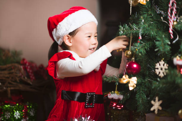 istock young girl decorating Christmas tree at home 1290666429