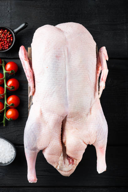 istock Raw whole farm duck on black wooden table, top view 1290667395