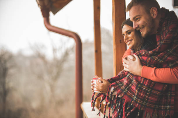 istock Young man embracing his girlfriend while they are relaxing on a patio 1290667578