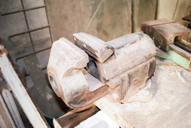 istock Old metal clamp in factory workshop. Metal rusty bench vice in dust, selective focus 1290669163