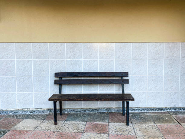 istock Wooden bench standing in front of the wall. 1290669249