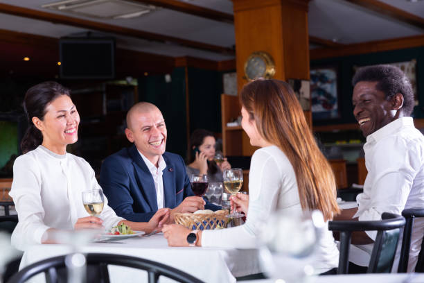 istock Group of people having dinner in cozy restaurant 1290671243