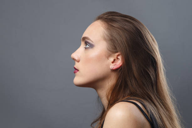 istock Image of young woman in profile on grey background 1290671250