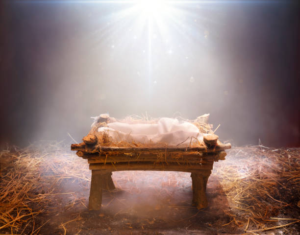 wachten op de messias - lege kribbe met licht dat op het valt - kerststal stockfoto's en -beelden