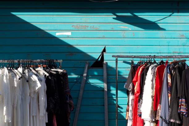 2 vintage clothing wearing in the street - Blue Iron Curtain background 2 wearers of vintage clothes in the street - Blue iron curtain background - fashion - fashion - second hand - flea markets - flea markets - flea markets clothing swap photos stock pictures, royalty-free photos & images