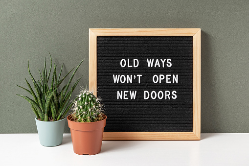 Old Ways Won't Open New Doors. Motivational quote on letter board, cactus, succulent flower on white table. Concept inspirational quote of the day. Front view.
