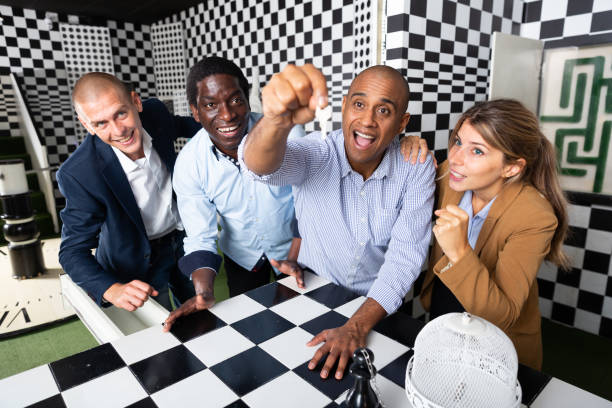 istock Colleagues playing in  chess quest room  during  team building 1290677039