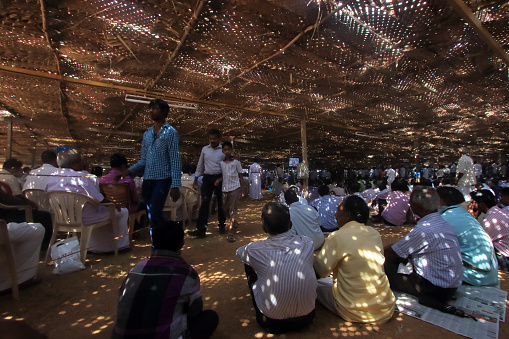 Kozhenchery, India -February 16,2014 : Devotees sitting under the shade attend the 'Maramon' convention in Kozhenchery, Kerala, India. It is one of the largest Christian conventions in Asia