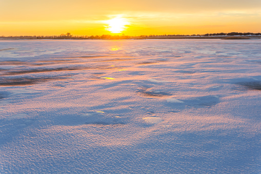 Magical winter wonderland with snow covered fields at sunrise
