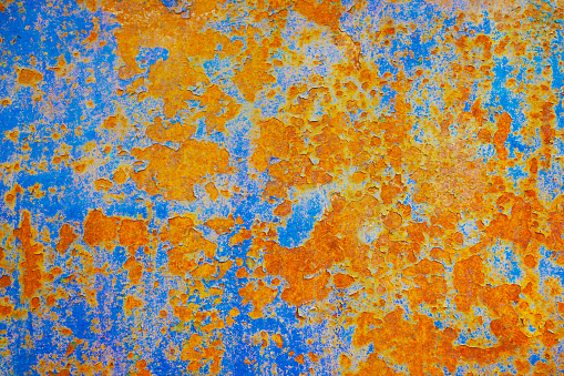 Rusty metal plate background. Orange blue abstract grunge texture background. Old rusty painted wall surface.