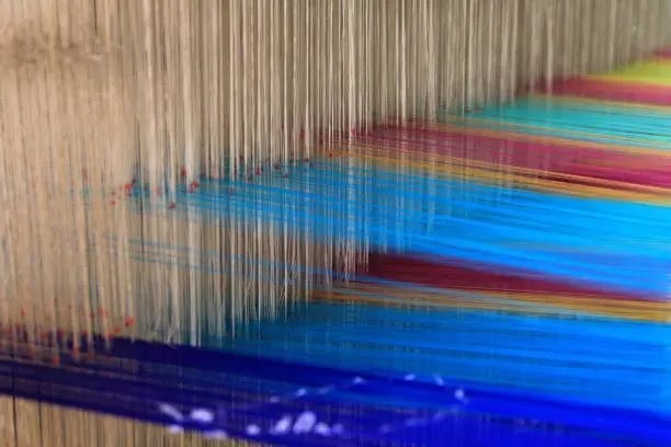Close up of selectively focused silk threads intertwined in a loom