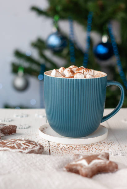 istock Hot cocoa in turquoise cup with marshmallows and gingerbread cookies on a white table 1290679689