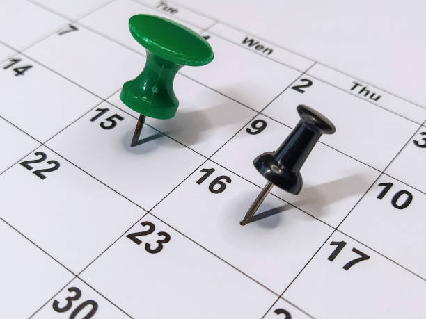 istock Green and black pushpins stuck into calendar, event reminder 1290679763