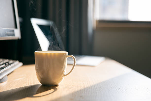 istock Hot coffee and computer on a wooden table 1290684052