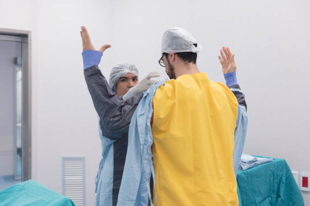 istock Assistant is helping surgeon putting on operating gown 1290688435