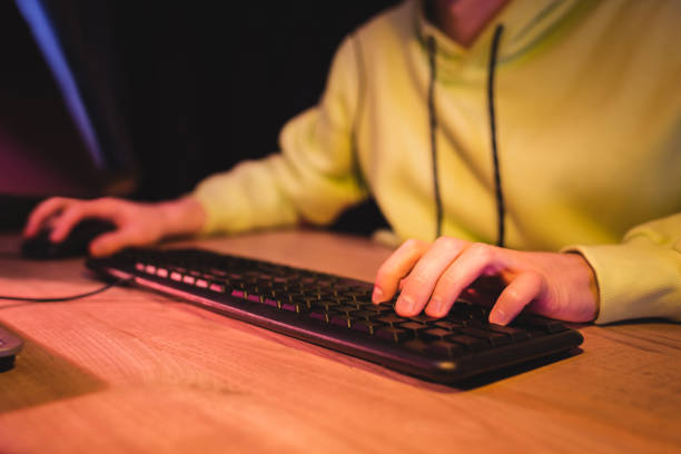 istock Cropped view of gamer using computer keyboard at table 1290690844