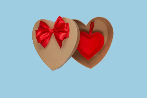 Heart shaped open gift box with a red bow on a blue background with a heart inside. Isolate. Valentine's Day Gift.