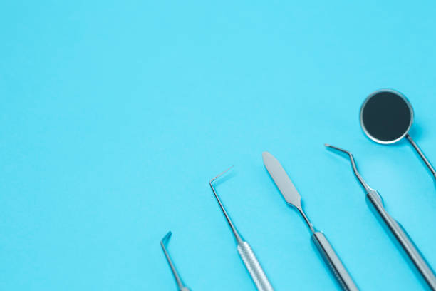 istock Dental  instruments on blue background and place for text. close-up 1290692263