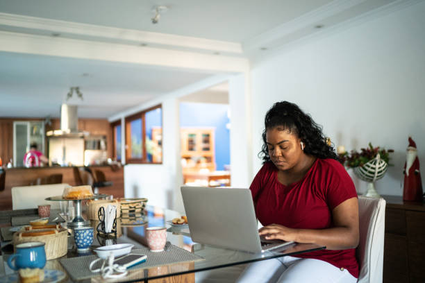 istock Young woman using laptop working from home 1290692539