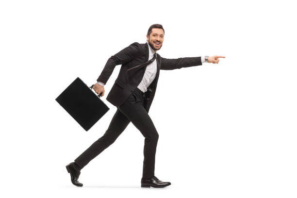 istock Handsome man in a black suit running with a briefcase and pointing forward 1290693483