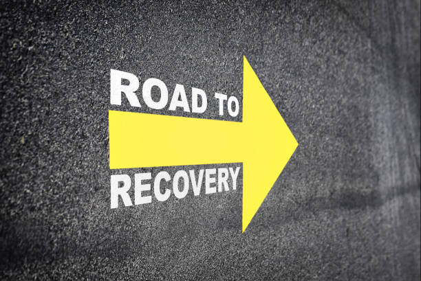 istock Recovery written with yellow arrow on road 1290693486
